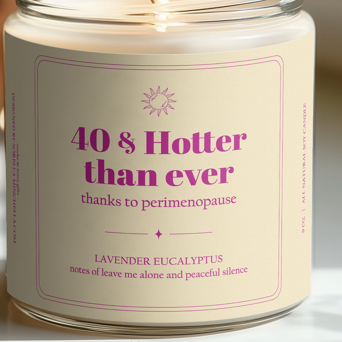Candle with a label reading '40 & Hotter than ever thanks to perimenopause' on a neutral background.
