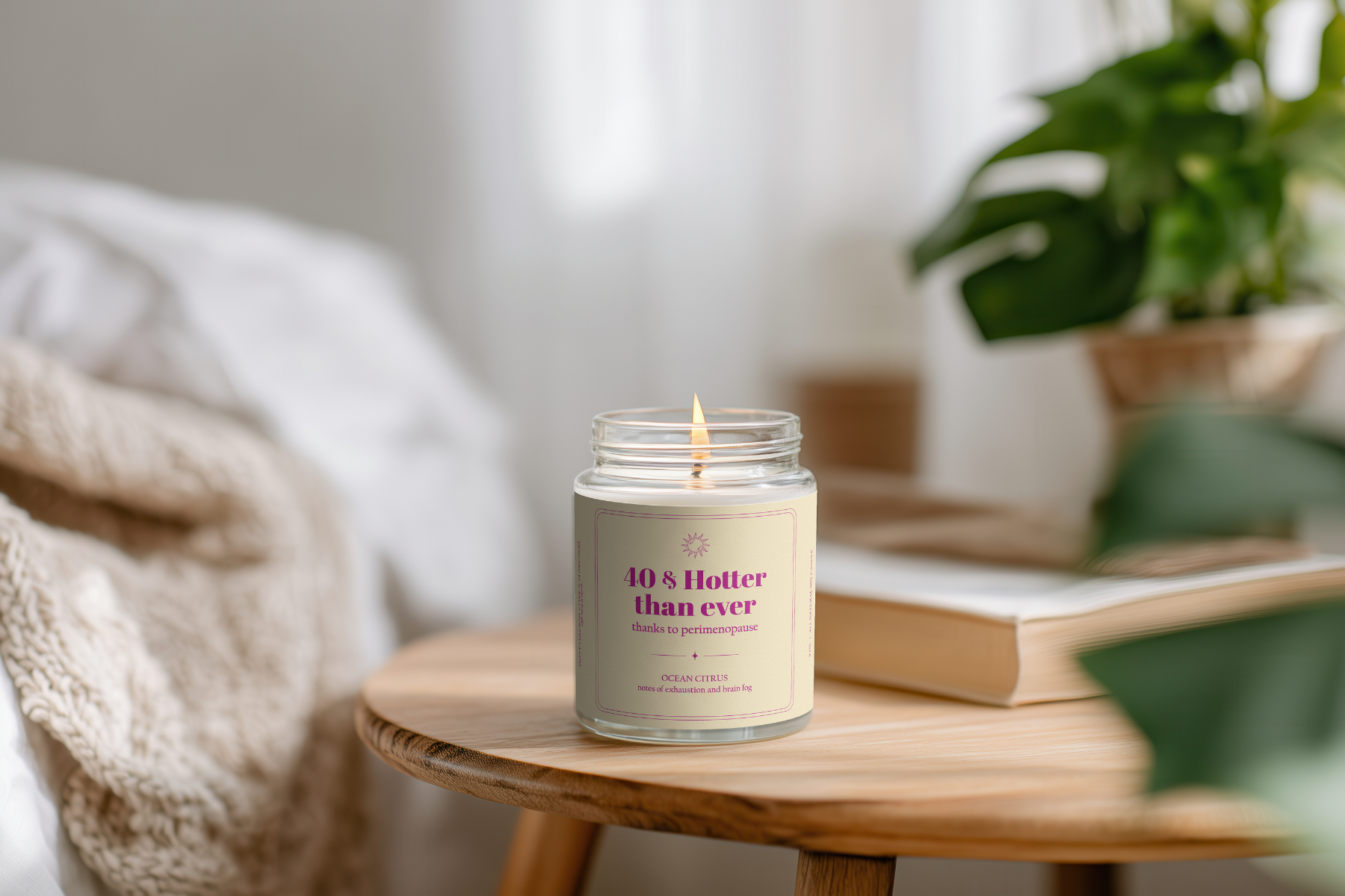 Candle in a glass jar labeled '10 & Hotter than ever' on a wooden table with a blurred background